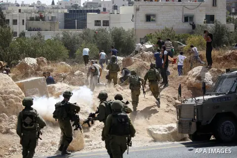 Palestinian run for cover from sound grenades during clashes following a protest against closure of a road south of the West Bank city of Hebron September 22, 2017. Photo by Wisam Hashlamoun