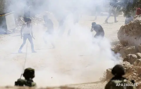 Palestinian run for cover from sound grenades during clashes following a protest against closure of a road south of the West Bank city of Hebron September 22, 2017. Photo by Wisam Hashlamoun