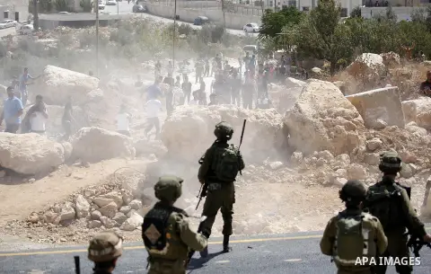 Palestinian run for cover from sound grenades during clashes following a protest against closure of a road south of the West Bank city of Hebron September 22, 2017. Photo by Wisam Hashlamoun