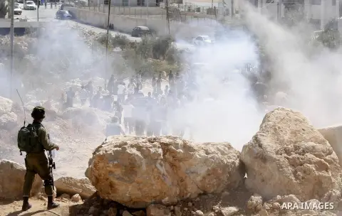 Palestinian run for cover from sound grenades during clashes following a protest against closure of a road south of the West Bank city of Hebron September 22, 2017. Photo by Wisam Hashlamoun