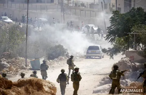 Palestinian run for cover from sound grenades during clashes following a protest against closure of a road south of the West Bank city of Hebron September 22, 2017. Photo by Wisam Hashlamoun