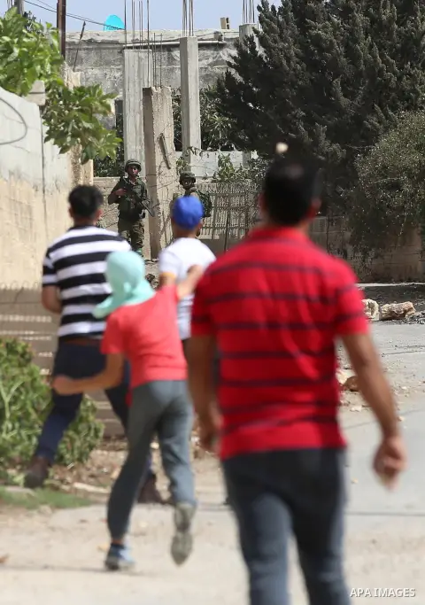 Palestinian protesters throw stones towards Israeli security forces during clashes following a demonstration against the expropriation of Palestinian land by Israel in the village of Kfar Qaddum, near Nablus in the occup...