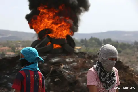 Palestinain protesters burn tires during clashes following a demonstration against the expropriation of Palestinian land by Israel in the village of Kfar Qaddum, near Nablus in the occupied West Bank, on September 22, 20...