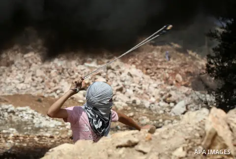 A Palestinian protester throws a stone towards Israeli security forces during clashes following a demonstration against the expropriation of Palestinian land by Israel in the village of Kfar Qaddum, near Nablus in the oc...