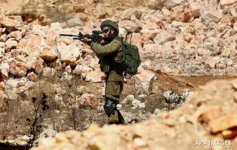 An Israeli soldier fires a tear gas canister during clashes following a demonstration against the expropriation of Palestinian land by Israel in the village of Kfar Qaddum, near Nablus in the occupied West Bank, on Septe...