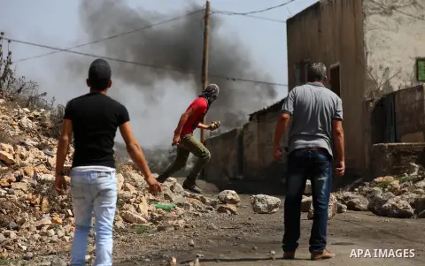 Palestinian protesters throw stones towards Israeli security forces during clashes following a demonstration against the expropriation of Palestinian land by Israel in the village of Kfar Qaddum, near Nablus in the occup...