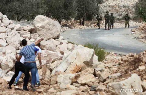 Palestinian protesters throw stones towards Israeli security forces during clashes following a demonstration against the expropriation of Palestinian land by Israel in the village of Kfar Qaddum, near Nablus in the occup...