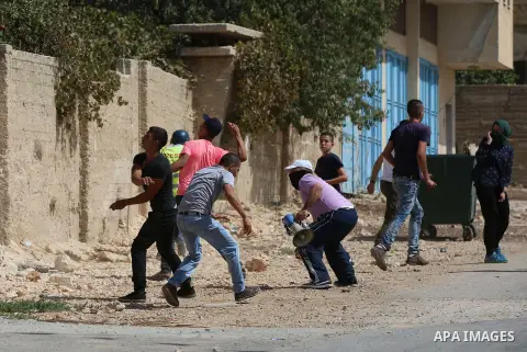 Palestinian protesters throw stones towards Israeli security forces during clashes following a demonstration against the expropriation of Palestinian land by Israel in the village of Kfar Qaddum, near Nablus in the occup...