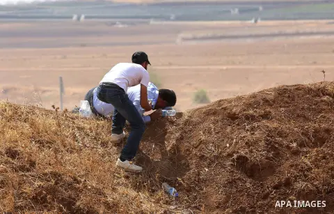 Palestinian protesters take cover from tear gas fired by Israeli security forces during clashes following a protest against the expropriation of Palestinian land in the village of Atouf, near the west bank city of Tubas...