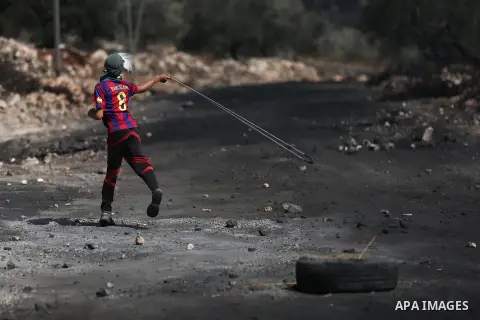 A Palestinian protester hurls stones towards Israeli troops during clashes near the Jewish settlement of Qadomem, in the West Bank village of Kofr Qadom near Nablus September 29, 2017. Photo by Ayman Ameen