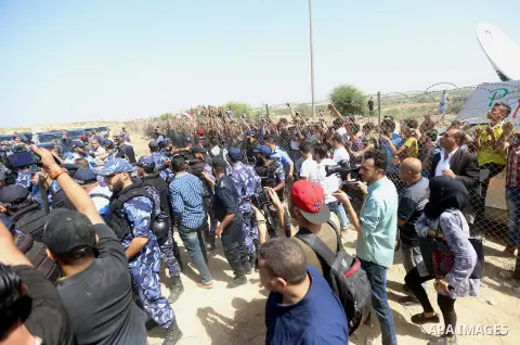 Palestinian Policemen try to hold back the crowd as the convoy of Palestinian Prime Minister Rami Hamdallah arrives to the Erez border crossing in the northern Gaza Strip on October 2, 2017. Hamdallah is on on his first...
