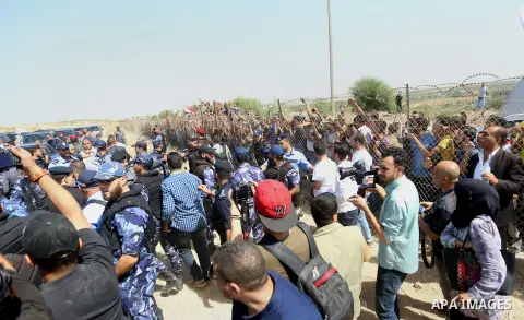 Palestinian Policemen try to hold back the crowd as the convoy of Palestinian Prime Minister Rami Hamdallah arrives to the Erez border crossing in the northern Gaza Strip on October 2, 2017. Hamdallah is on on his first...