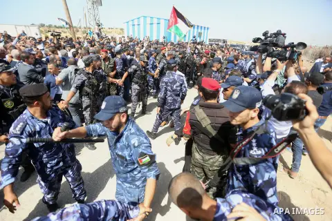 Palestinian Policemen try to hold back the crowd as the convoy of Palestinian Prime Minister Rami Hamdallah arrives to the Erez border crossing in the northern Gaza Strip on October 2, 2017. Hamdallah is on on his first...