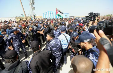 Palestinian Policemen try to hold back the crowd as the convoy of Palestinian Prime Minister Rami Hamdallah arrives to the Erez border crossing in the northern Gaza Strip on October 2, 2017. Hamdallah is on on his first...