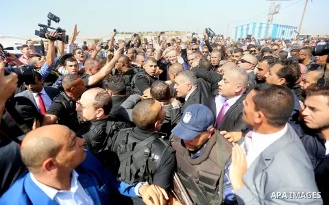 Palestinian Prime Minister Rami Hamdallah is surrounded by security as he waves following his arrival at the Erez border crossing in the northern Gaza Strip on October 2, 2017. Hamdallah is on on his first visit to the G...