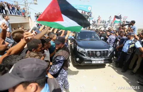 Palestinians celebrate as the convoy of Palestinian Prime Minister Rami Hamdallah and his government ministers arrive to the Erez border crossing in the northern Gaza Strip on October 2, 2017. Hamdallah is on on his firs...