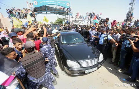 Palestinians celebrate as the convoy of Palestinian Prime Minister Rami Hamdallah and his government ministers arrive to the Erez border crossing in the northern Gaza Strip on October 2, 2017. Hamdallah is on on his firs...
