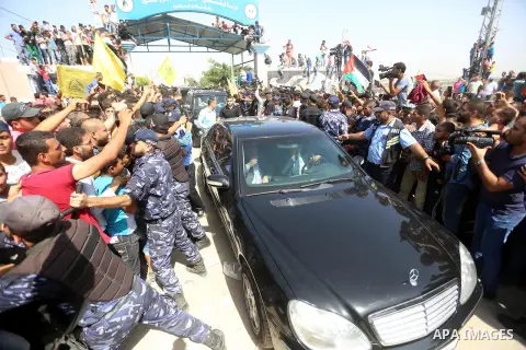 Palestinians celebrate as the convoy of Palestinian Prime Minister Rami Hamdallah and his government ministers arrive to the Erez border crossing in the northern Gaza Strip on October 2, 2017. Hamdallah is on on his firs...