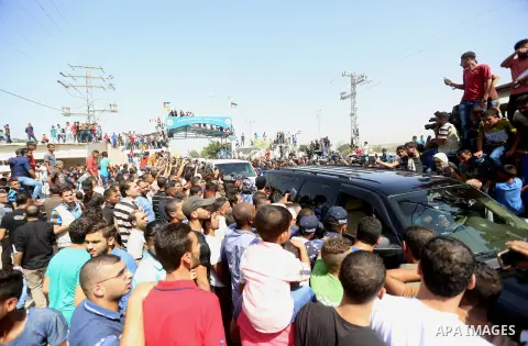 Palestinians celebrate as the convoy of Palestinian Prime Minister Rami Hamdallah and his government ministers arrive to the Erez border crossing in the northern Gaza Strip on October 2, 2017. Hamdallah is on on his firs...