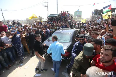 Palestinians celebrate as the convoy of Palestinian Prime Minister Rami Hamdallah and his government ministers arrive to the Erez border crossing in the northern Gaza Strip on October 2, 2017. Hamdallah is on on his firs...