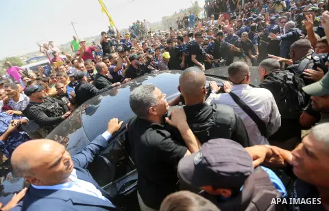 Palestinians celebrate as the convoy of Palestinian Prime Minister Rami Hamdallah and his government ministers arrive to the Erez border crossing in the northern Gaza Strip on October 2, 2017. Hamdallah is on on his firs...