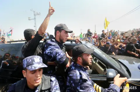 Palestinians celebrate as the convoy of Palestinian Prime Minister Rami Hamdallah and his government ministers arrive to the Erez border crossing in the northern Gaza Strip on October 2, 2017. Hamdallah is on on his firs...