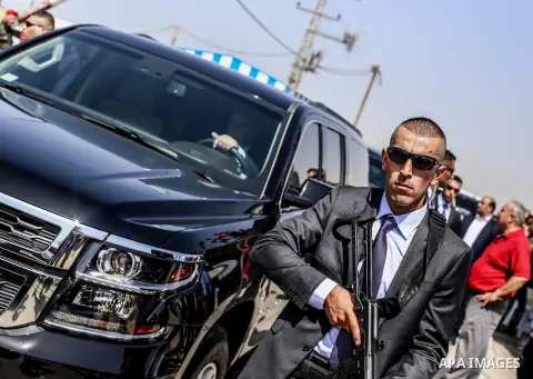 Palestinian security officers surround the vehicle carrying Prime Minister Rami Hamdallah upon his arrival with his government at Erez crossing in the northern Gaza Strip on October 2, 2017. Palestinian prime minister Ra...