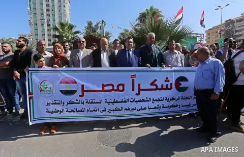 Palestinians hold banners near the Palestinian government headquarters in Gaza City on October 3, 2017. Photo by Yasser Qudih