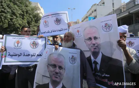 Palestinians hold banners in a protest demanding thier rights outside the Palestinian cabinet headquarter during a reconciliation cabinet meeting in Gaza City on October 3, 2017. The Palestinian reconciliation government...