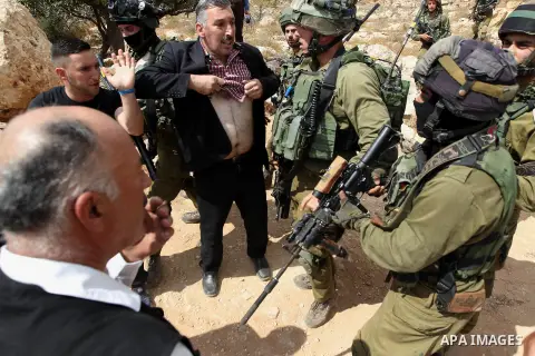A Palestinian protester argues with Israeli security forces during a protest demanding the reopening of the main road to the Qalqas village that was closed by Israel almost 17 years ago in the West Bank city of Hebron Oc...