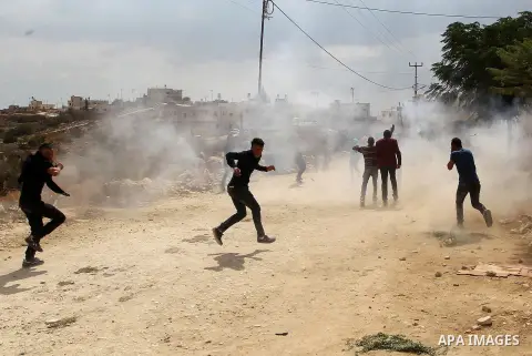 Palestinian protesters run for cover during clashes with Israeli security forces at a protest demanding the reopening of the main road to the Qalqas village that was closed by Israel almost 17 years ago in the West Bank...