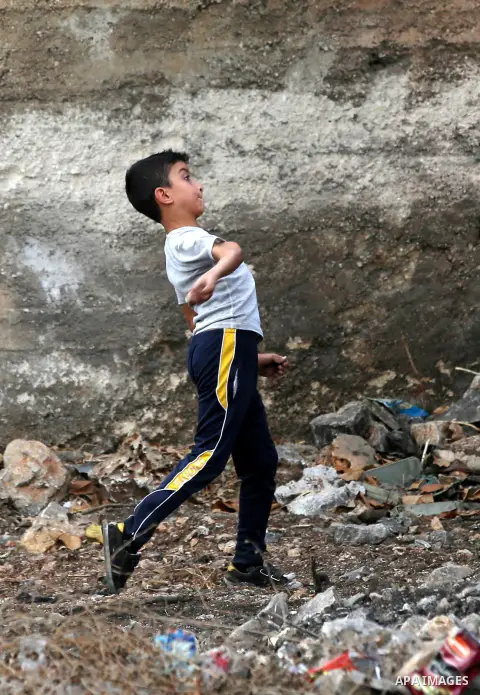 A Palestinian protester throws stones towards Israeli security forces during clashes following a demonstration against the expropriation of Palestinian land by Israel in the village of Kfar Qaddum, near Nablus in the occ...
