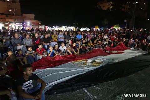 Palestinian fans watch the World Cup 2018 Africa qualifying football match between Egypt and Congo via large screens in Gaza City on October 8, 2017. Photo by Mohammed Asad