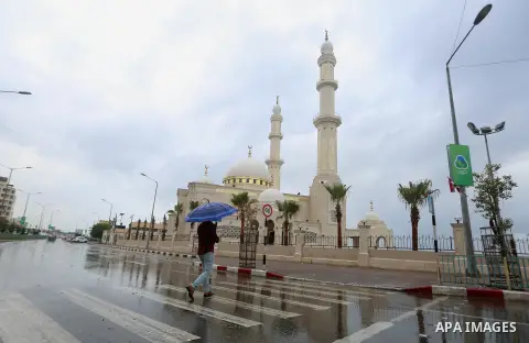 A Palestinian man walks in a street flooded by rain water, in Gaza city on October 9, 2017. Photo by Atia Darwish
