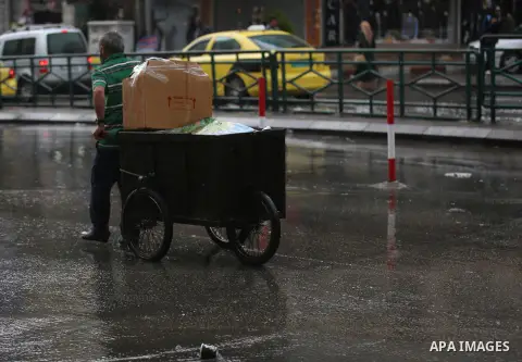 Palestinians walk in a street flooded by rain water, in the West Bank city of Nablus, on October 9, 2017. Photo by Ayman Ameen