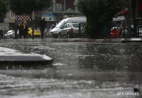 Palestinians walk in a street flooded by rain water, in the West Bank city of Nablus, on October 9, 2017. Photo by Ayman Ameen