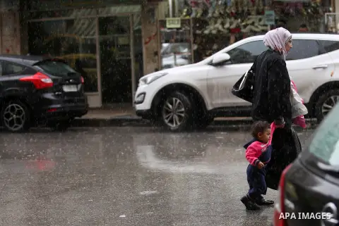 Palestinians walk in a street flooded by rain water, in the West Bank city of Nablus, on October 9, 2017. Photo by Ayman Ameen