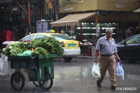 Palestinians walk in a street flooded by rain water, in the West Bank city of Nablus, on October 9, 2017. Photo by Ayman Ameen
