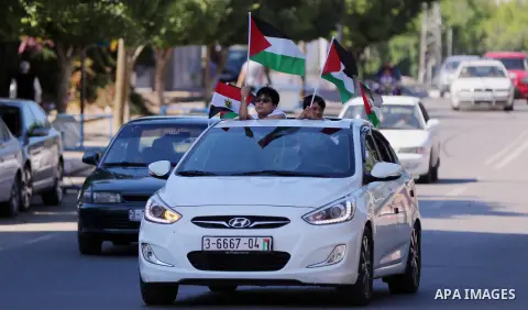 Palestinians wave the flags of Egypt, Palestine, Fatah and Hamas as they gather in Gaza City to celebrate after rival Palestinian factions Hamas and Fatah reached an agreement on ending a decade-long split following talk...