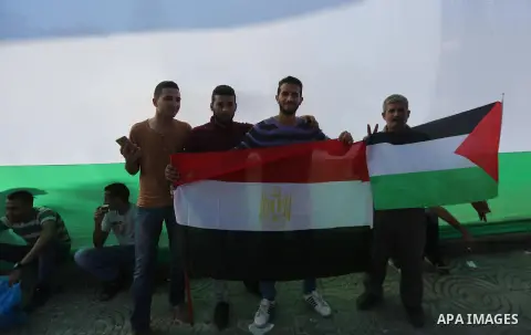 Palestinians wave the flags of Egypt, Palestine, Fatah and Hamas as they gather in Gaza City to celebrate after rival Palestinian factions Hamas and Fatah reached an agreement on ending a decade-long split following talk...