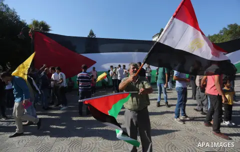 Palestinians wave the flags of Egypt, Palestine, Fatah and Hamas as they gather in Gaza City to celebrate after rival Palestinian factions Hamas and Fatah reached an agreement on ending a decade-long split following talk...