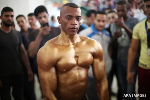 A Palestinian participant prepares himself before a bodybuilding competition, which organized by Palestinian Federation of Bodybuilding and Fitness (PFBB), in Gaza city on October 20, 2017. Photo by Mohammed Asad