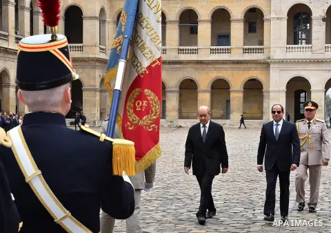 French Foreign Affairs Minister Jean-Yves Le Drian and Egypt's President Abdel Fattah al-Sisi listen to the national anthem with Paris' military Governor Bruno le Ray as they stand in front of an honour guard at the Hote...