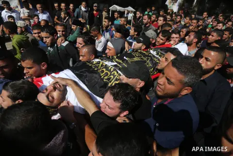 Palestinian mourners carry the body of one of the Palestinians killed in an Israeli operation to blow up a tunnel stretching from the Gaza Strip into Israel during their funeral in Bureij refugee camp in central Gaza Str...
