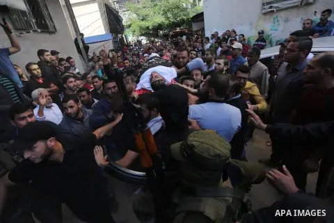 Palestinian mourners carry the body of one of the Palestinians killed in an Israeli operation to blow up a tunnel stretching from the Gaza Strip into Israel during their funeral in Bureij refugee camp in central Gaza Str...