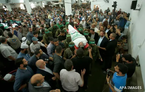 Palestinian mourners and fighters from the Ezzedine al-Qassam Brigades, the armed wing of the Palestinian Hamas movement, carry the body of 22-year-old Mohammed Alagha in Khan Yunis, in the southern Gaza Strip, on Octobe...