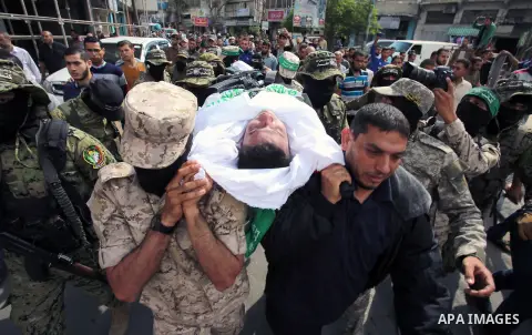 Palestinian mourners and fighters from the Ezzedine al-Qassam Brigades, the armed wing of the Palestinian Hamas movement, carry the body of 30-year-old Mosbah Shabir in Khan Yunis, in the southern Gaza Strip, on October...