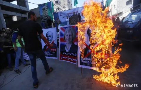 Palestinian supporters of Hamas movement burn a poster of British Prime Minister Theresa May during a protest against the 100th anniversary of Britain's Balfour Declaration in Gaza city on November 3, 2017, which helped...