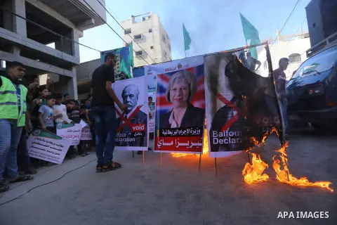 Palestinian supporters of Hamas movement burn a poster of British Prime Minister Theresa May during a protest against the 100th anniversary of Britain's Balfour Declaration in Gaza city on November 3, 2017, which helped...