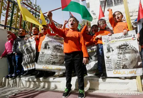 Palestinian children take part in a rally to mark the 13th anniversary of the death of late Palestinian leader Yasser Arafat, in the West Bank city of Hebron, on November 12, 2017. Photo by Wisam Hashlamoun